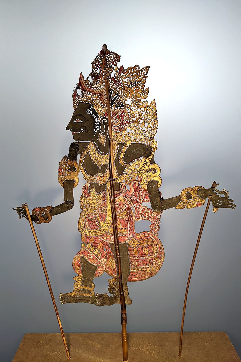 Wayang Kulit-figur til skyggespil  u.å.<br>Udskåret bøffellæder bemalet i farver og guld